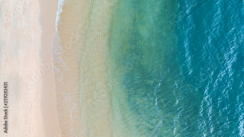 Photography Aerial top view of Beach with shade emerald blue water and wave foam on tropical