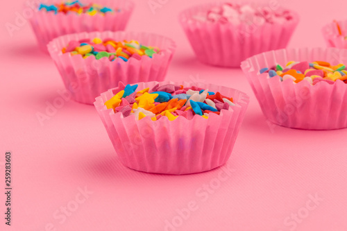 Sugar sprinkles food background on pink cardboard