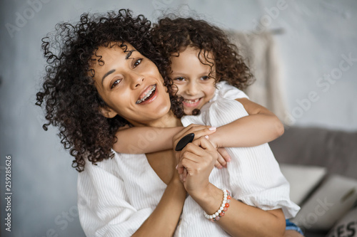 Happy Women's Day. Mom and daughter. Mom and girl are smiling with braces of African-American appearance.
