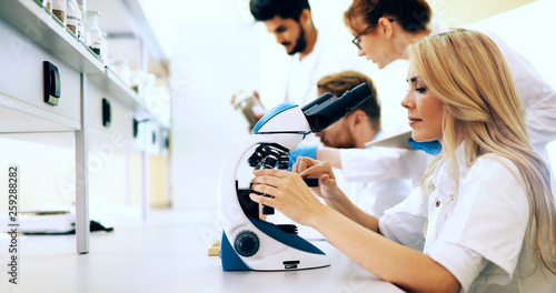 Tableau sur toile Young scientist looking through microscope in laboratory