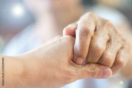 Caregiver  Specialized Assistance  carer hand holding elder hand woman in hospice care. Philanthropy kindness to disabled concept.Public Service Recognition Week