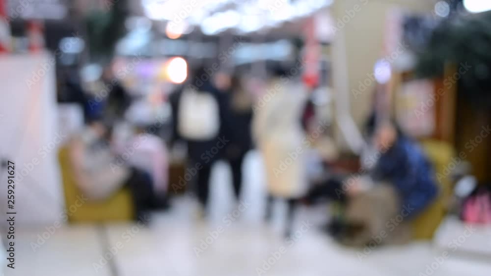 Many people walk inside the mall or store with illumination. Many people walk inside the mall or store with illumination.