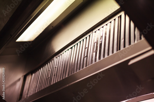 Kitchen hood (exhaust hood, range hood), device containing mechanical fan hanging above stove in kitchen. It removes airborne grease, fumes, smoke, heat and steam by evacuation of air and filtration