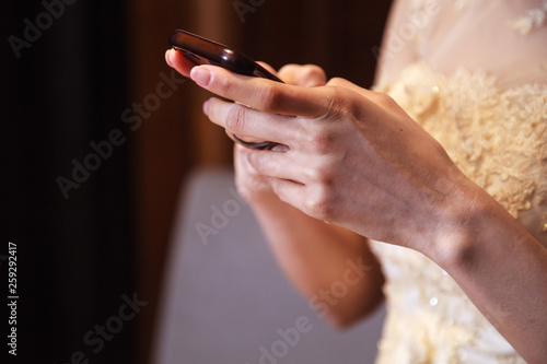 Bride in wedding gown using smart mobile phone, Shopping and Communicating with digital technology. Modern Trend, Lifestyle, Business Transaction, Communication, Working online and Mobile App concept