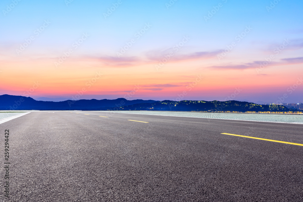 Fototapeta premium Asphalt road and beautiful mountain nature landscape at sunset