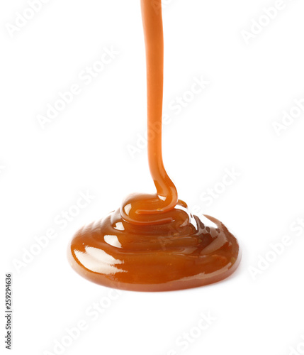 Pouring liquid caramel on white background