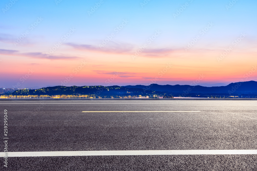 Fototapeta premium Asphalt road and beautiful mountain nature landscape at sunset