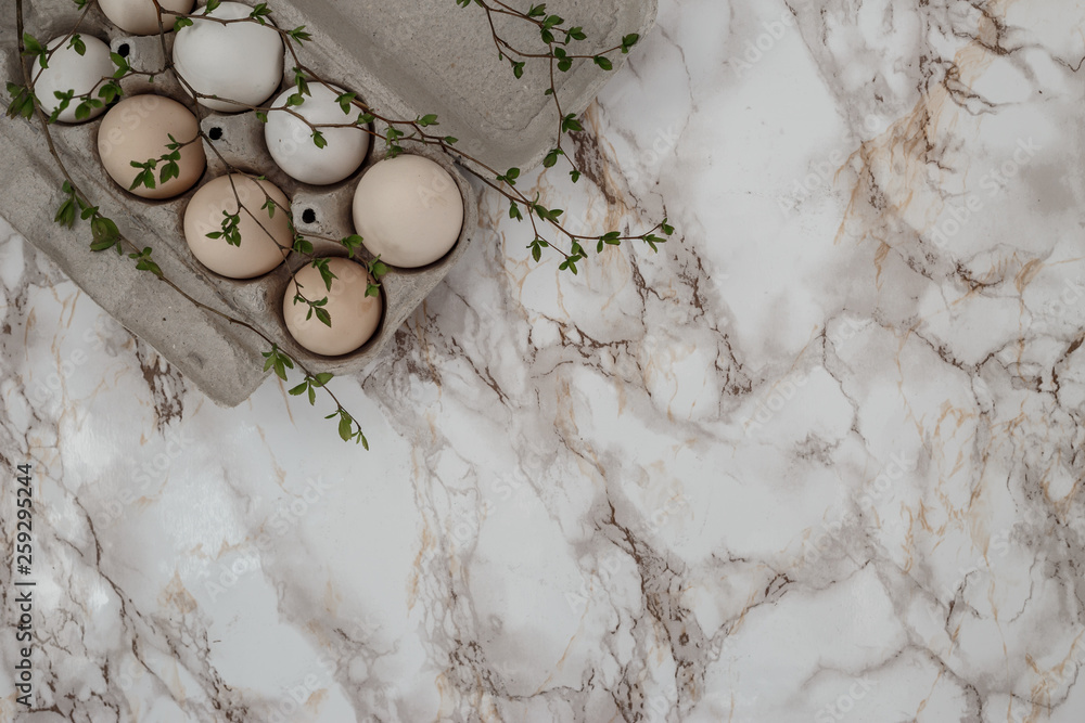 Easter eggs on marble background. A sprig of greenery.Place for inscription. top view Easter eggs on marble background. A sprig of greenery.Place for inscription. top view