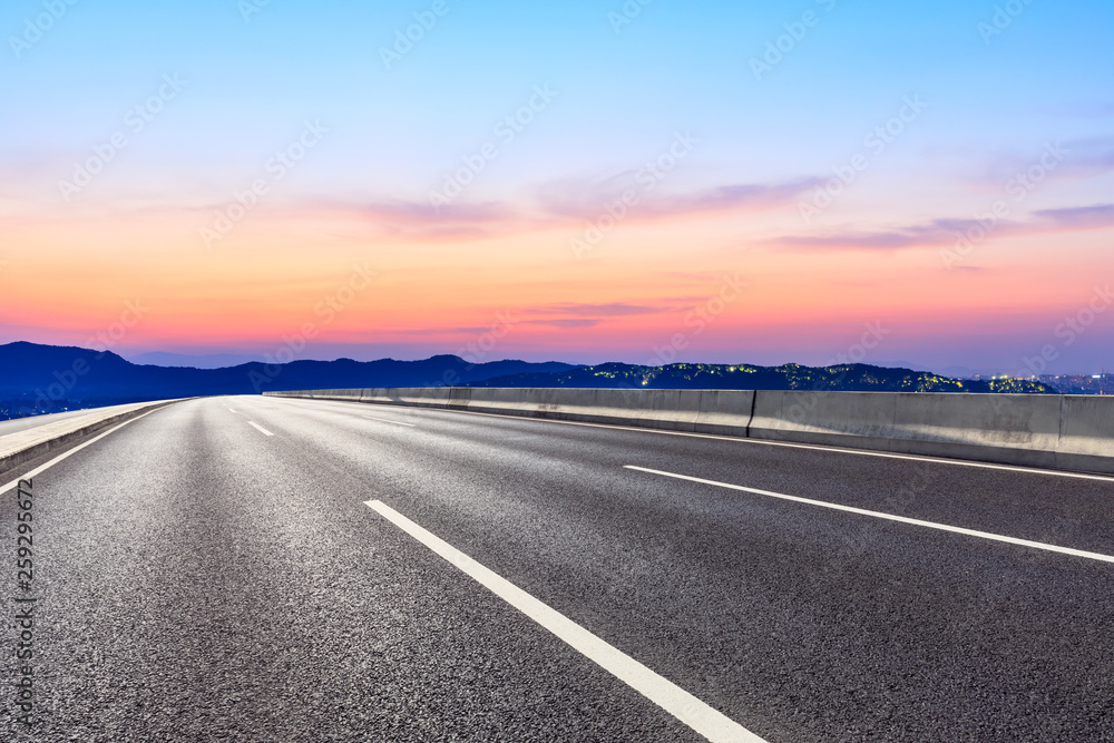 Fototapeta premium Asphalt road and beautiful mountain nature landscape at sunset