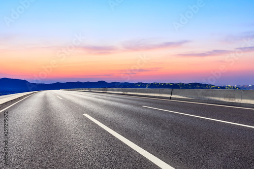 Asphalt road and beautiful mountain nature landscape at sunset © ABCDstock