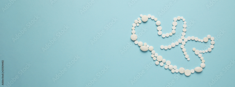 Silhouette of a human embryo (child) from white tablets on a blue background. Treatment of newborns, medical care. Silhouette of a human embryo (child) from white tablets on a blue background. Treatment of newborns, medical care.