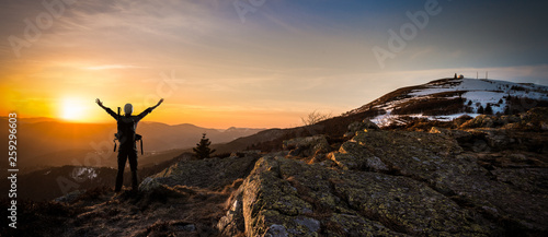 Alpiniste face à l'horizon en haut d'une montagne photo