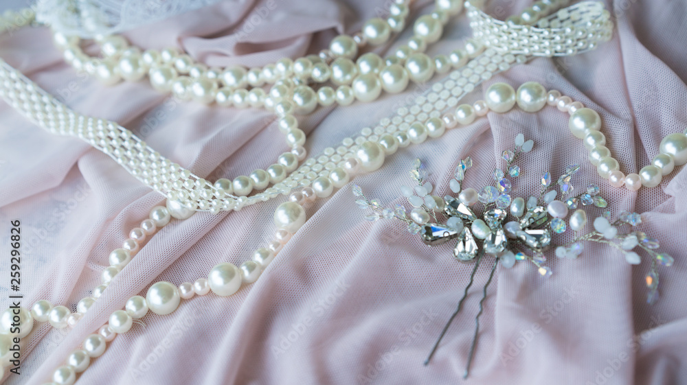 Obraz premium Wedding background with pearls and hair accessories on pink background