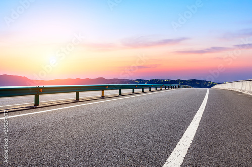 Asphalt road and beautiful mountain nature landscape at sunset