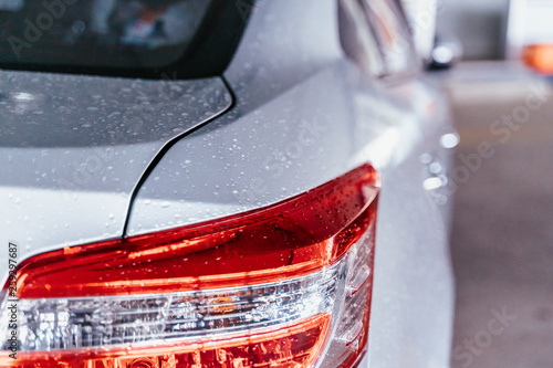Water droplet on the car hood. Water beading after rain or car wash on white shiny paint surface. Beading created by ceramic coat or paint sealant with high surface tension. Water drop Backgroud.