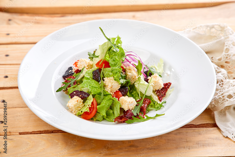 vegetarian salad with dried tomatoes and croutons on the wooden background vegetarian salad with dried tomatoes and croutons on the wooden background