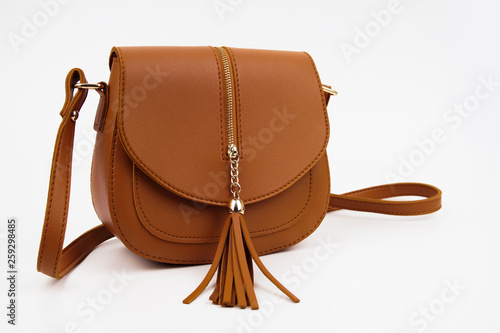 Brown synthetic leather sling handbag isolated on white background photo