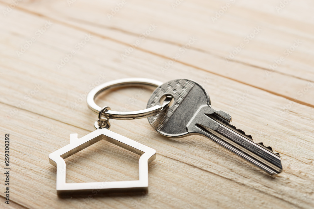 House key with a keychain on wooden desk concept for real estate House key with a keychain on wooden desk concept for real estate