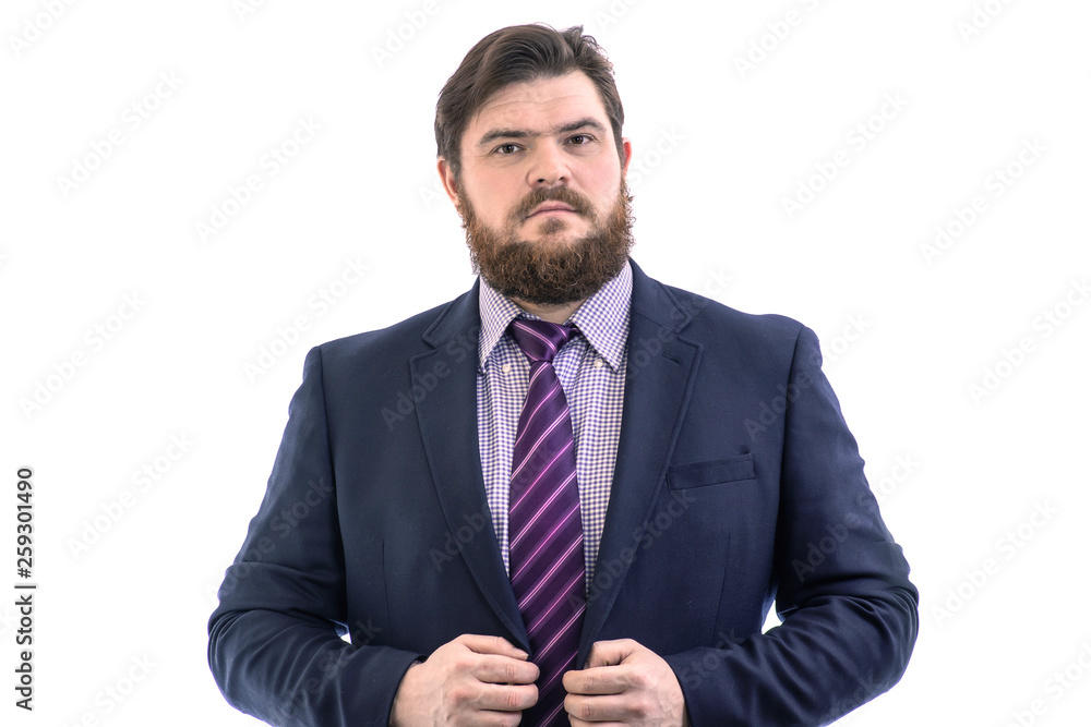 Portrait of a big handsome serious bearded business man in a dark suit and a bright blue tie, isolated on white