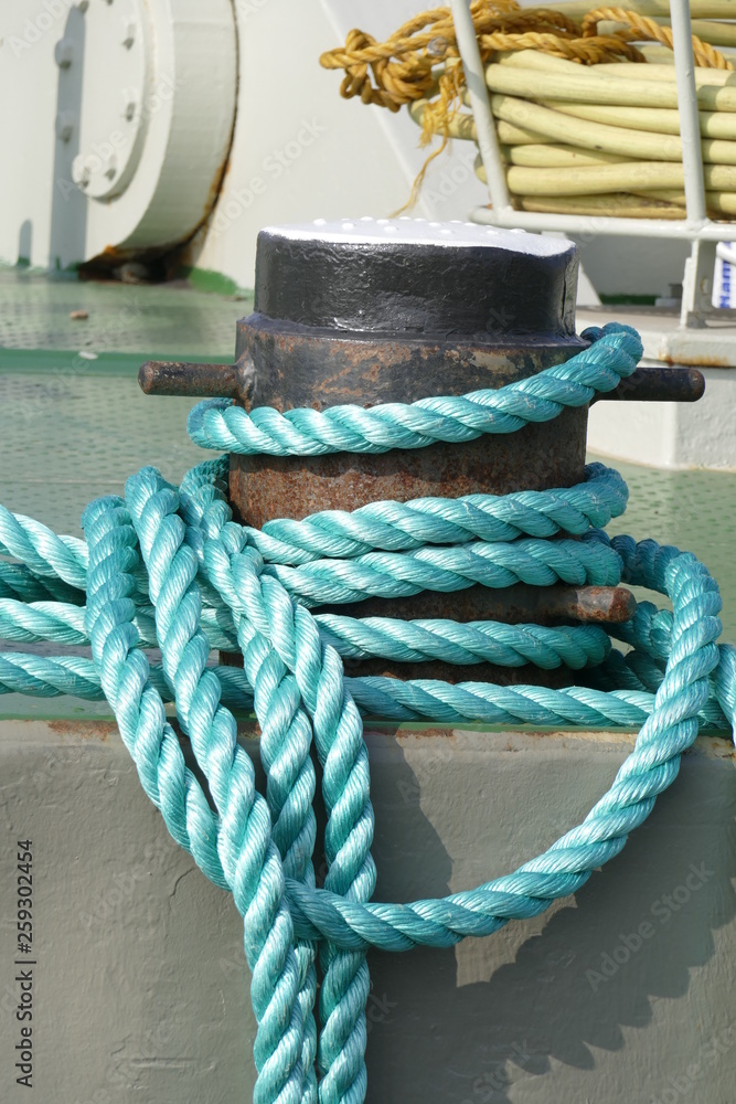 Fototapeta premium Verknotetes Schiffstau an einem Poller im Hafen