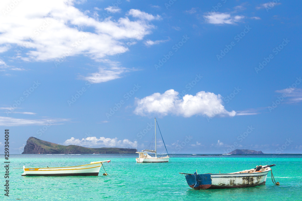 Fishing boats in the turquoise water at Cap Malheureux in the north of Mauritius, Africa.
