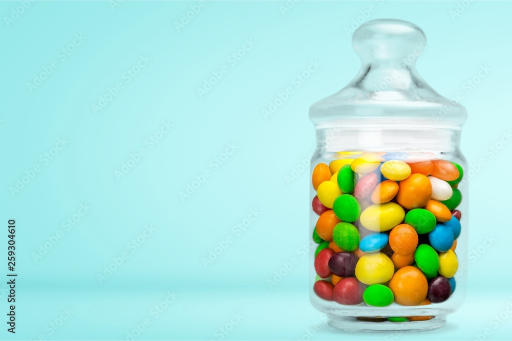 Transparent glass jar with colorful chocolate candies Transparent glass jar with colorful chocolate candies