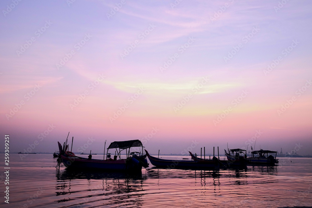 Sunrise at a bay of water and fishing port, the calm sea in low tide, a tranquil scene in morning mood
