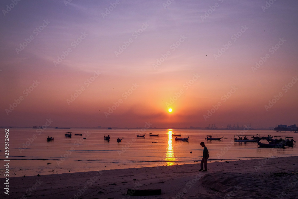Silhouette of a boys enjoying the sunrsie at the beach in Penang Malaysia Silhouette of a boys enjoying the sunrsie at the beach in Penang Malaysia