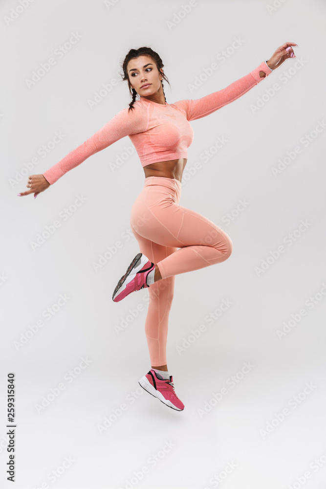 Amazing strong sports fitness woman posing isolated over white wall background.