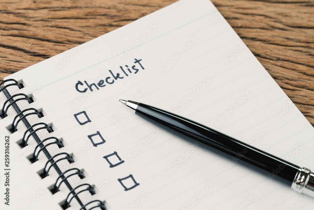 Checklist, to do list, prioritize or reminder for project plan, pen with handwriting headline the word Checklist and check box on small notepad on wood table Checklist, to do list, prioritize or reminder for project plan, pen with handwriting headline the word Checklist and check box on small notepad on wood table