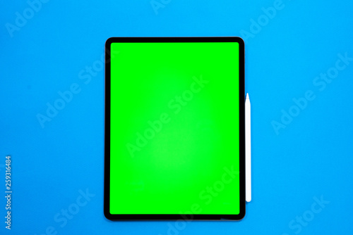 new tablet on a Blue background with and pen, and green screen