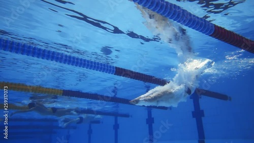 Muscular man under water in a swimming pool in super slow motion photo