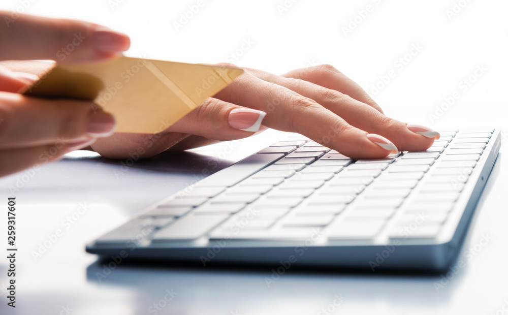 Hands holding a credit card and using laptop computer for online shopping Hands holding a credit card and using laptop computer for online shopping