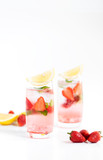 iced strawberry punch cocktail in glass with lemon on white background. summer drink.