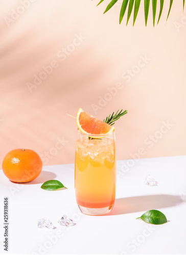 Cold and refreshing orange punch cocktail with orange slice on color background. summer drink.