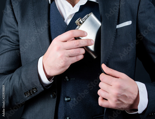 alcohol abuse of man has bad addiction. bachelor and single. businessman in suit. concept of alcohol abuse. male with beard put flask in pocket. male drink alcohol. alcohol abuse. hangover photo