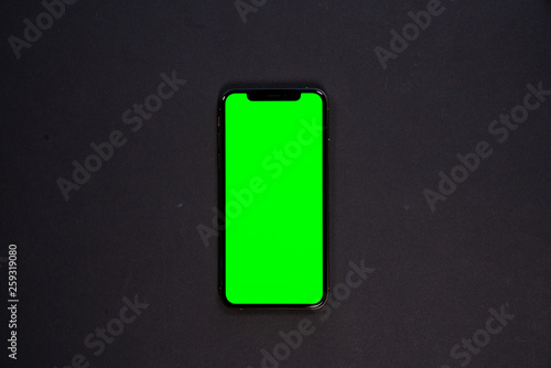 iPhone XS, smartphone, green screen on Black background top view