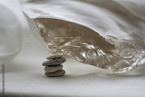 Canvas Print beautiful large transparent crystal standing on several small flat stones on a b