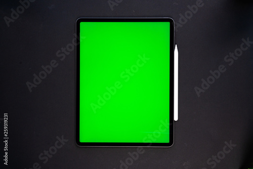 new tablet on a Black background with a keyboard and pen, and green screen top view