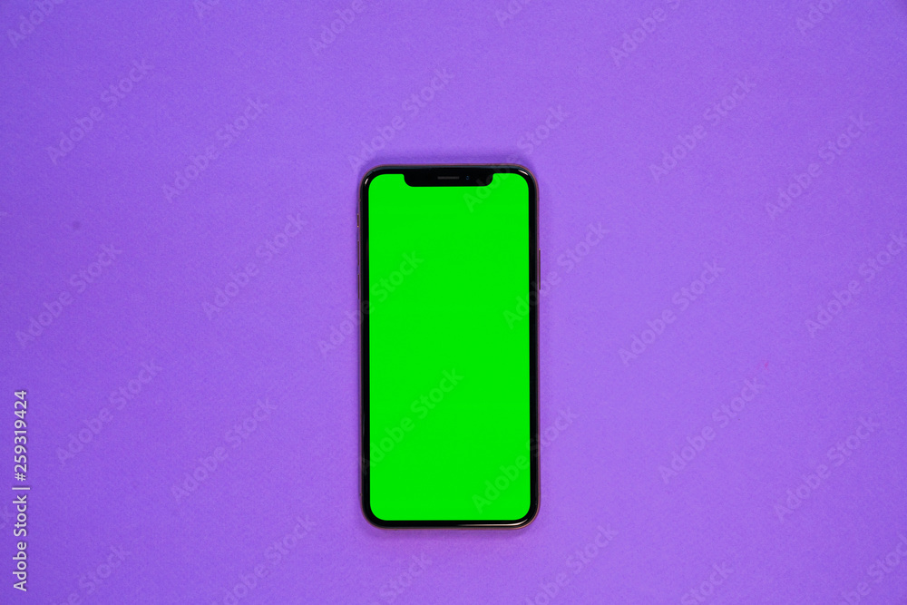 iPhone XS, smartphone, green screen on Violet background top view iPhone XS, smartphone, green screen on Violet background top view