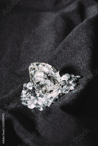 pile of shiny pure diamonds on black textured cloth