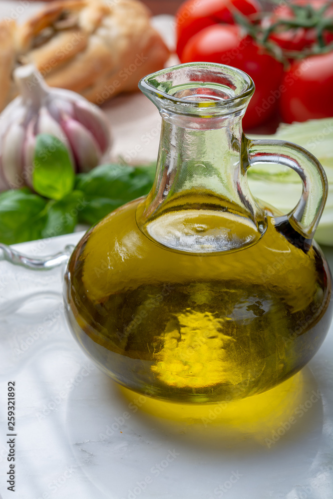 Virgin natural olive oil is glass bottle, served with traditional Mediterranean food Virgin natural olive oil is glass bottle, served with traditional Mediterranean food