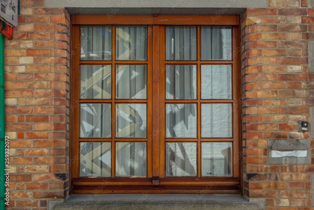 Brown wooden window on brick wall - obrazy, fototapety, plakaty 