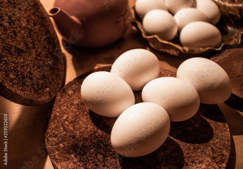 Eggs on a wooden plate in a wooden surrouding background photo