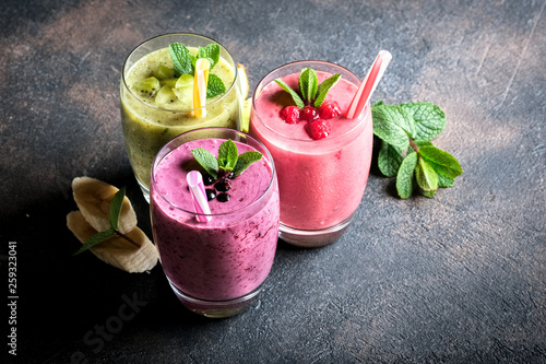 Fruit and berry smoothie blend at home against a dark background top view copy space.