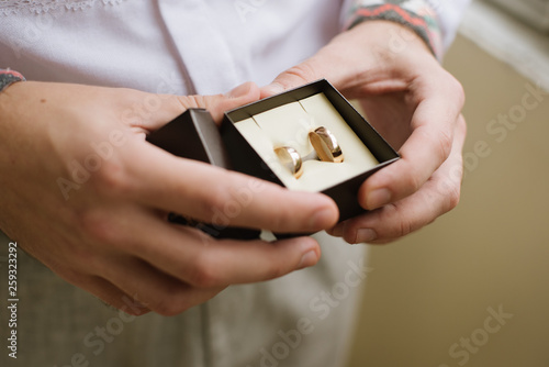 close up photo of groom hand's holding wedding rings box. wedding, grooms morning concept
