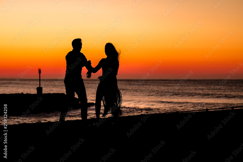 Couple dancing on the pier during sunrise make for awesome silhouettes