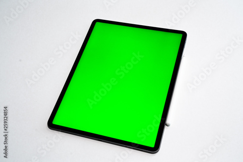 new iPad, tablet on a white background with a keyboard and pen, and green screen