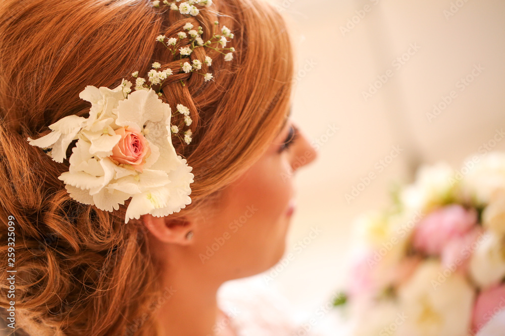 Naklejka premium Happy blonde woman posing in w2edding dress with bouquet of flowers in hands