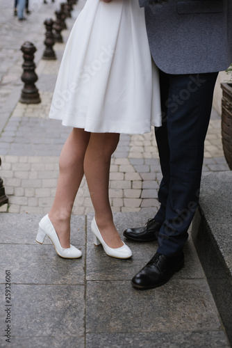 Close up photo of grooms legs standing on the street outdoor, wedding details